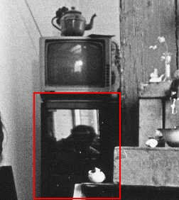 Onder het zwart-wit teeveetje met oude theepot is in de spiegelende deur van de audio-set het gebogen hoofd van de hurkende fotograaf Louis te zien.