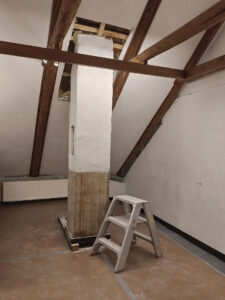 Deels vrijgemaakte lange schoorsteen in het Mankes Kabinet, steekt boven het dakschild nog zeker weer zo'n lengte uit.